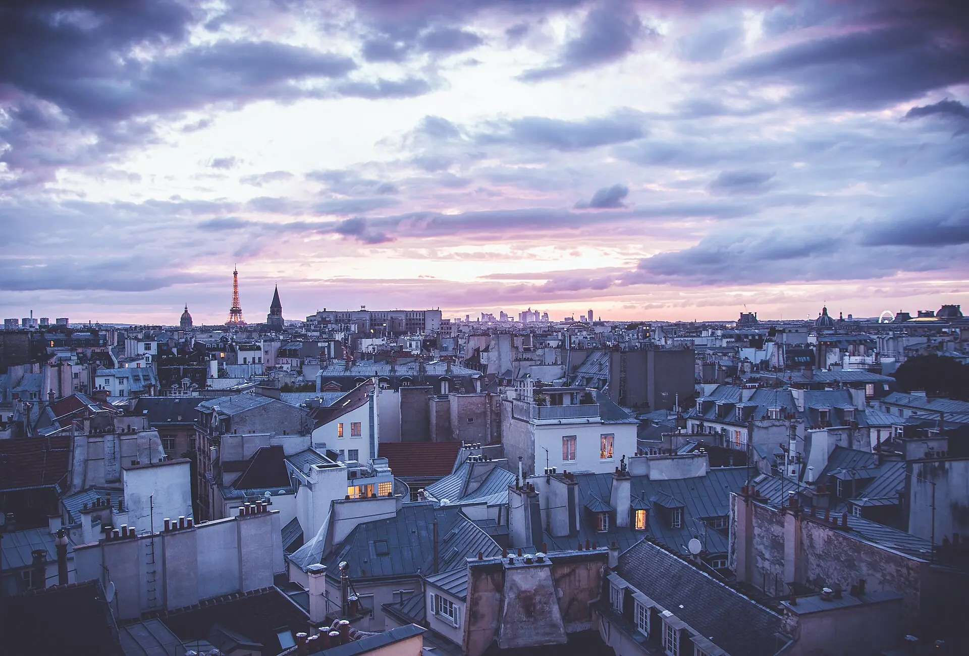 Paris rooftops at dusk under a violet sky